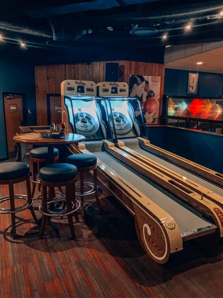 high top seating area next to two skeeball machines