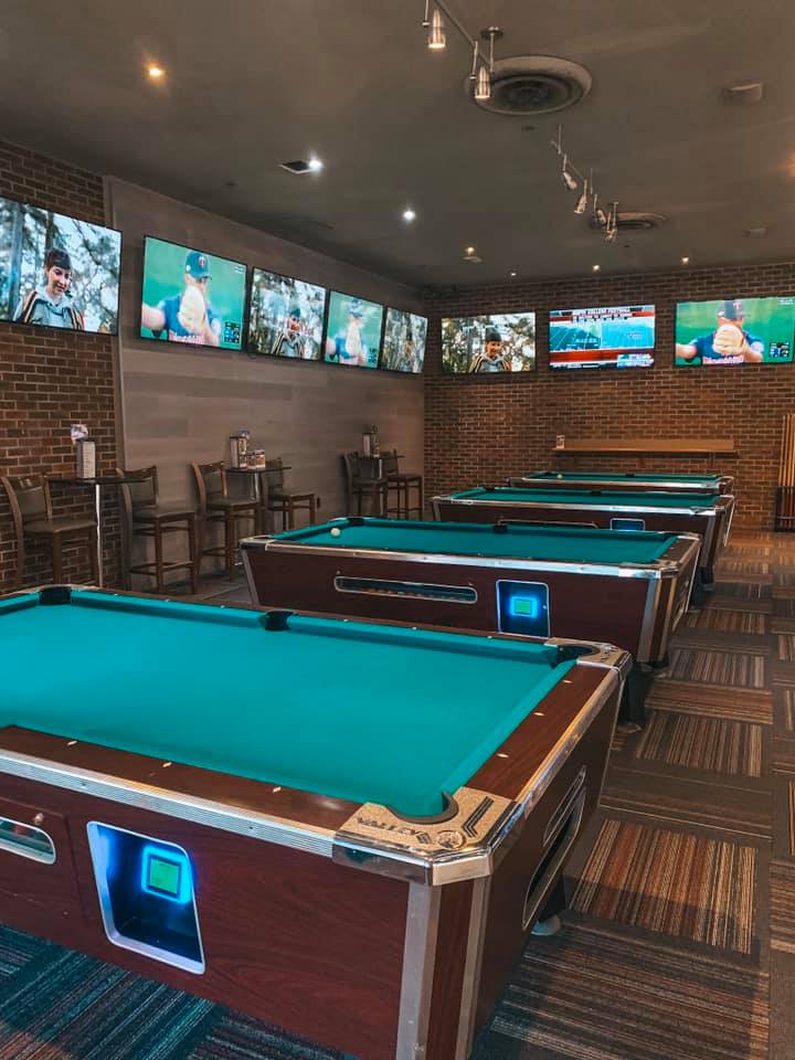 three pool tables surrounded by several tvs airing football games at a fun bar in Tampa called Gametime