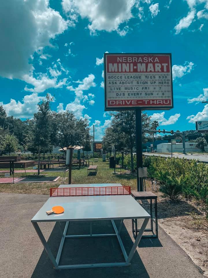 Nebraska Mini Mart sign with an outdoor ping pong table