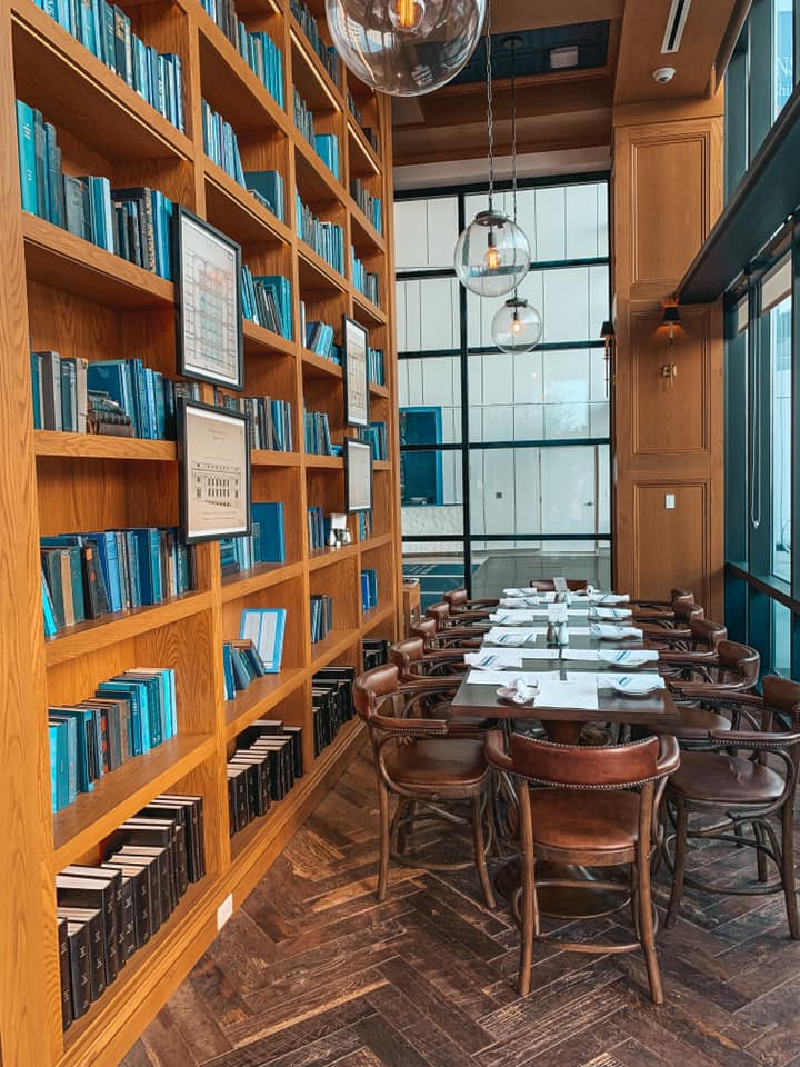 blue books lining bookshelves behind a dining area