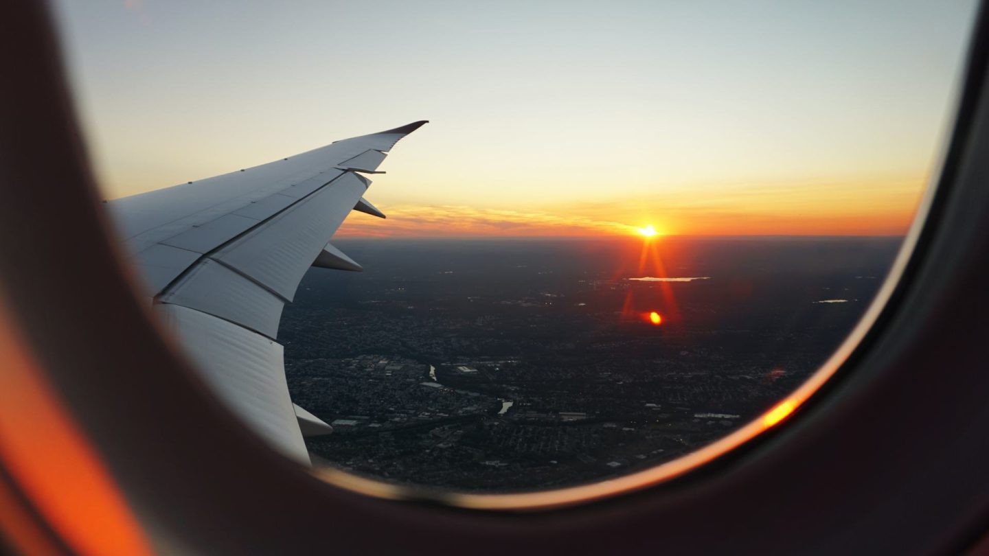 Looking out plane window on the way to a trip with travel insurance