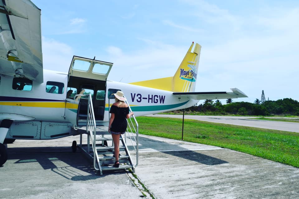 woman getting on a small plane getting ready to fly alone for the first time to Belize with travel insurance