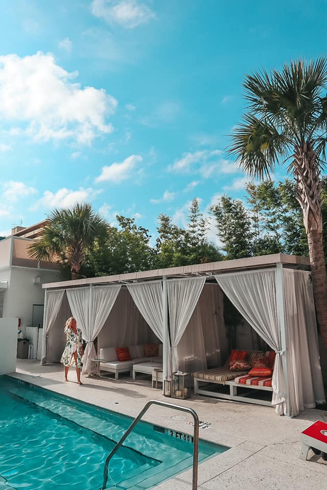 Woman walking along the pool and cabanas at Sarasota Modern in Sarasota, Florida