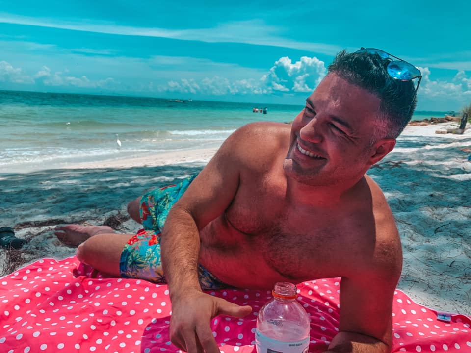Man smiling while laying out on the Florida Beach
