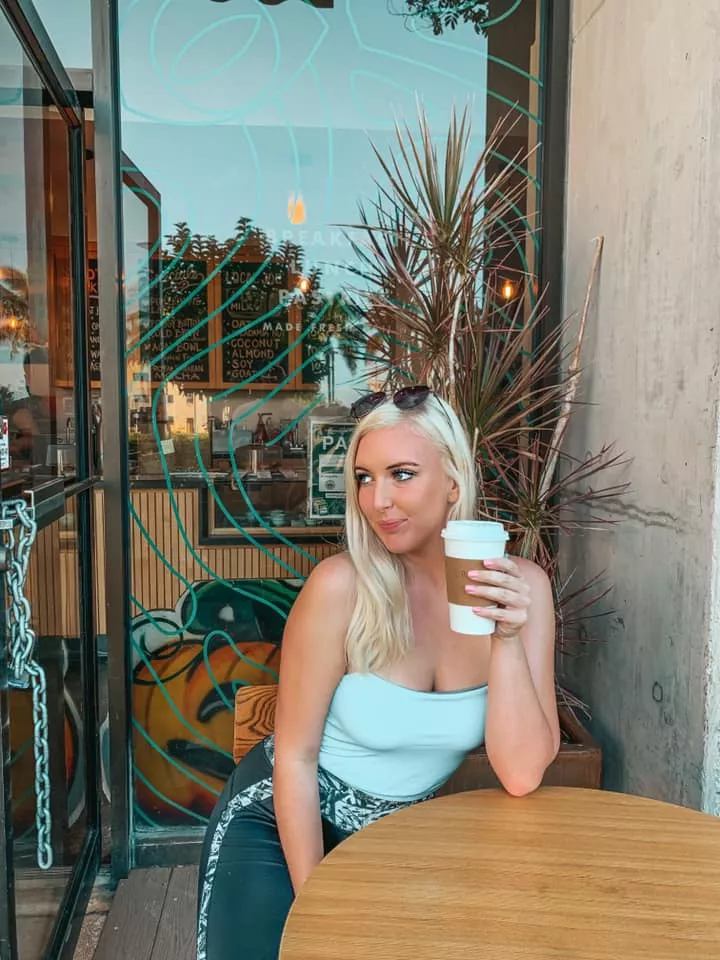 Woman enjoying cup of coffee outside of Local Joe in Honolulu