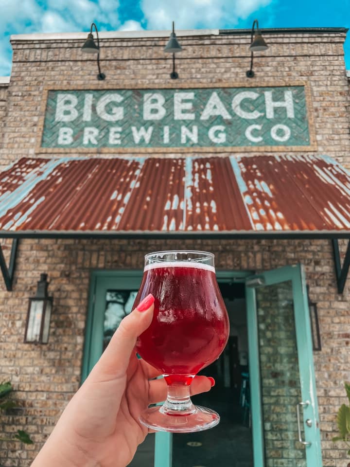 Holding up Fruiturama sour in front of Big Beach Brewing Co entrance