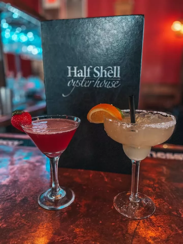 Martini and margarita in front of Half Shell Oyster House menu