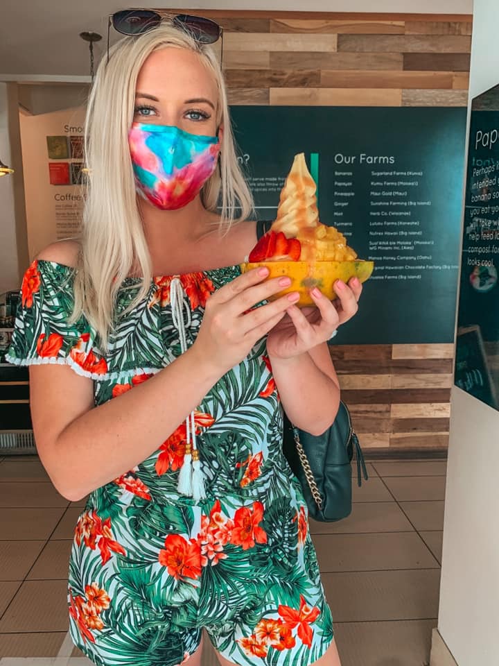 holding banan up in a papaya boat