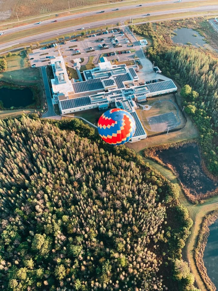 looking down at another hot air balloon flying through Tampa Bay