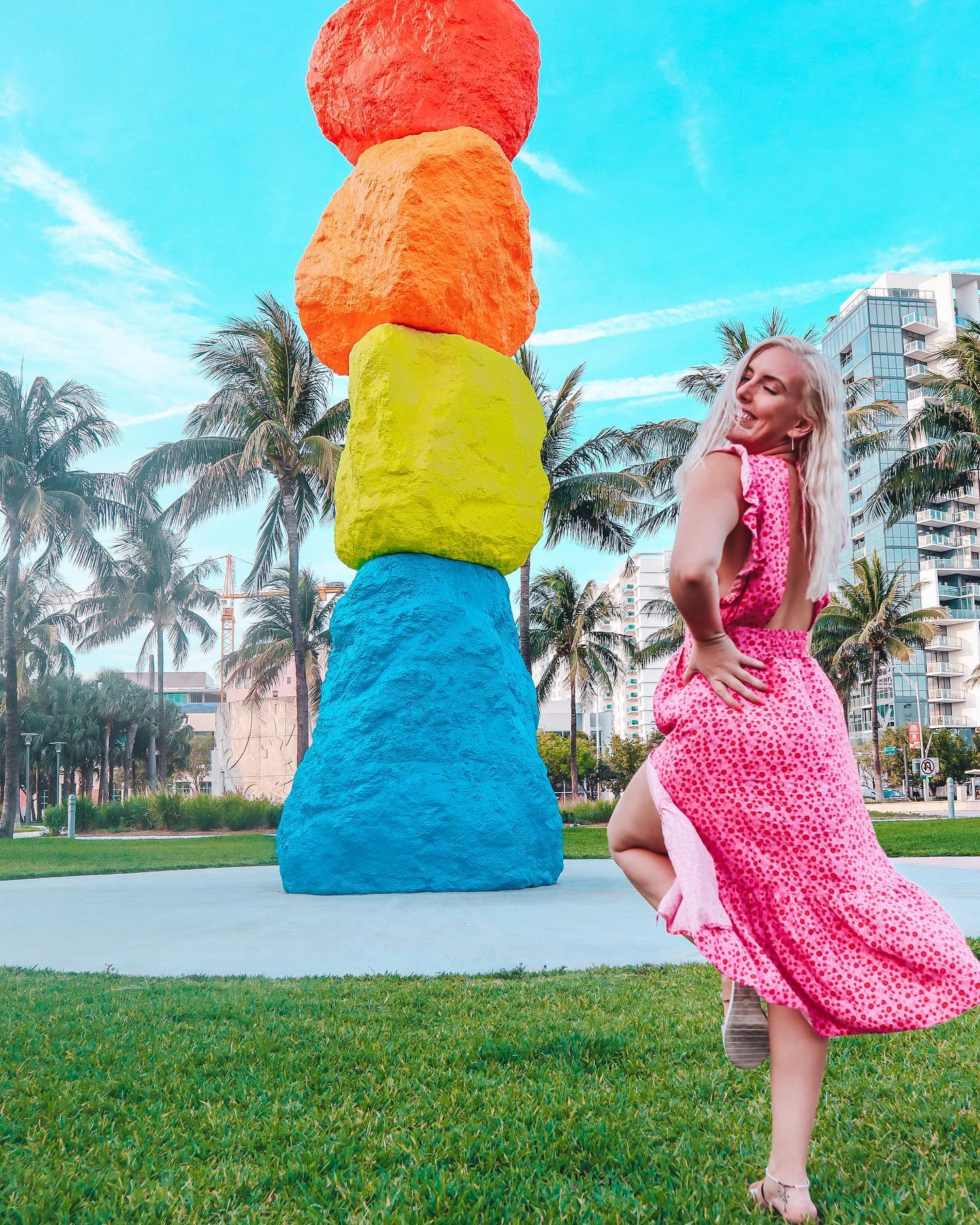 Woman in a beautiful dress posing in front of the 8th Magic Mountain in Miami