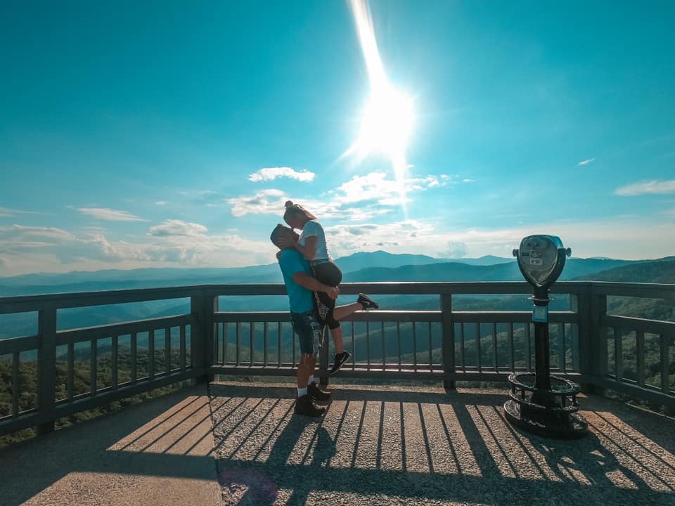 Couple kissing at a lookout point of Blowing Rock