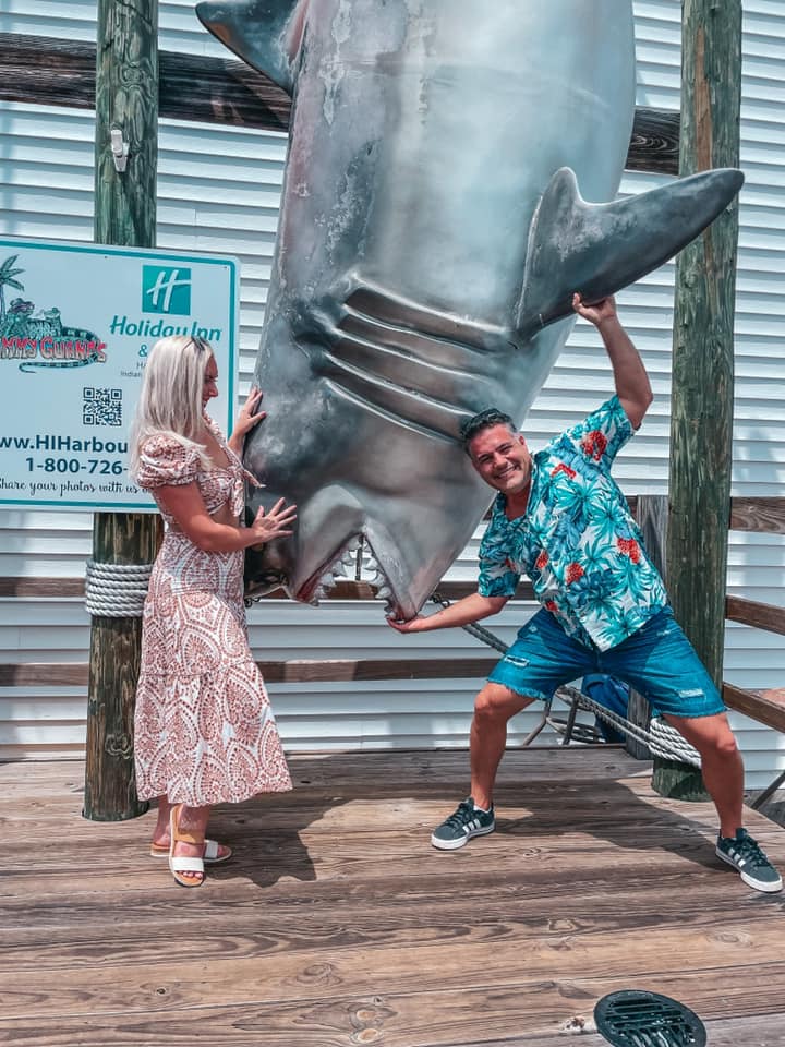 couple posing with large, fake hanging shark at Holiday Inn Indian Rocks Beach