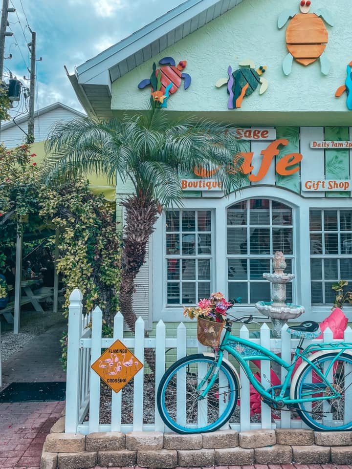 Sweet Sage Cafe entrance with a bike parked along a white picket fence