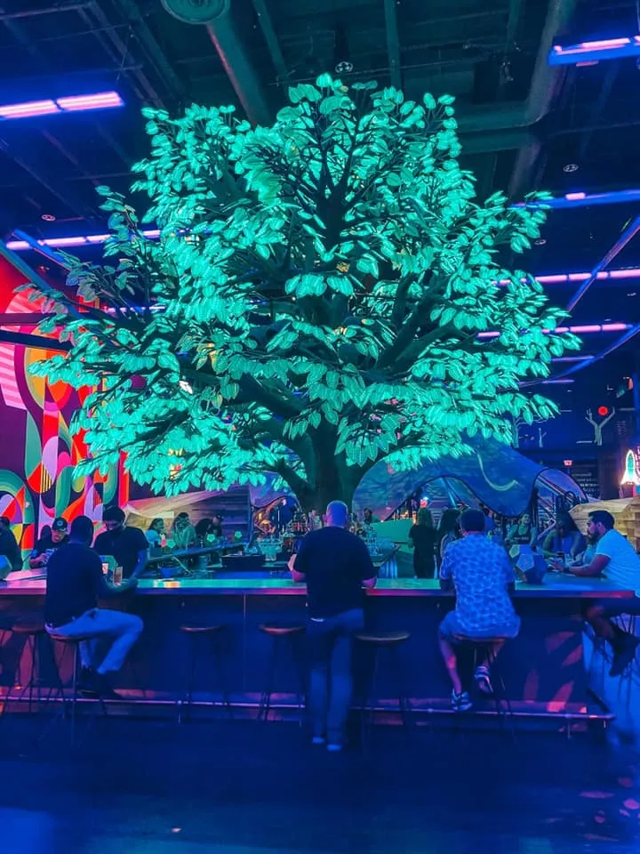 neon glowing tree and bar area inside of Area 15 in Vegas