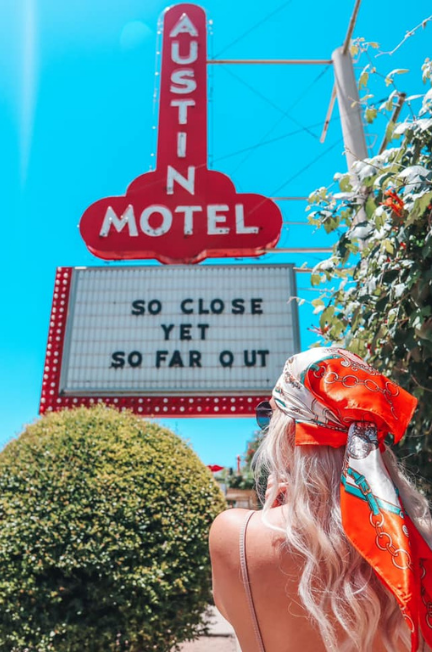 Austin Motel with sign that reads "so close yet so far out"