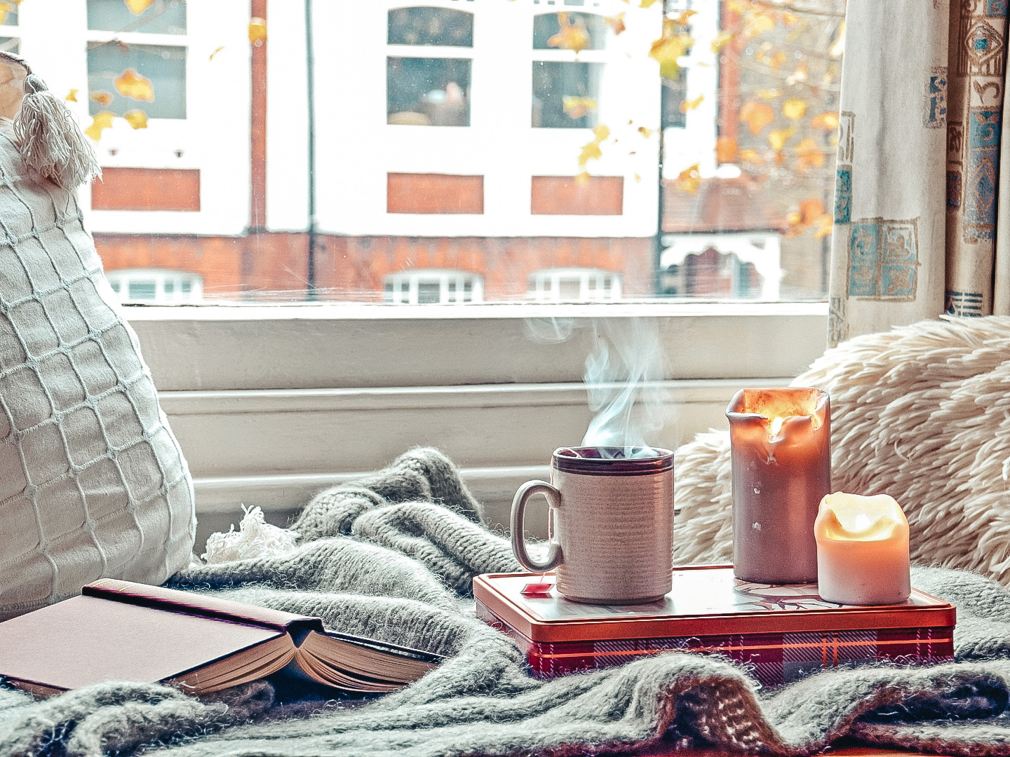 cozy home with candles, books, and coffee after moving to a city alone