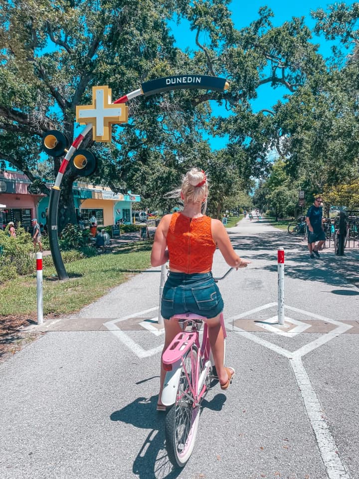 Sitting on a pink bike entering the Pinellas Trail in Dunedin