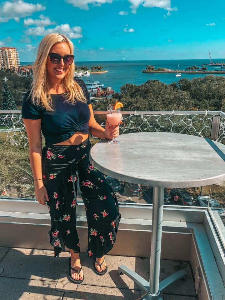 wearing an all black outfit enjoying a frose at The Canopy rooftop bar in downtown St. Pete Florida