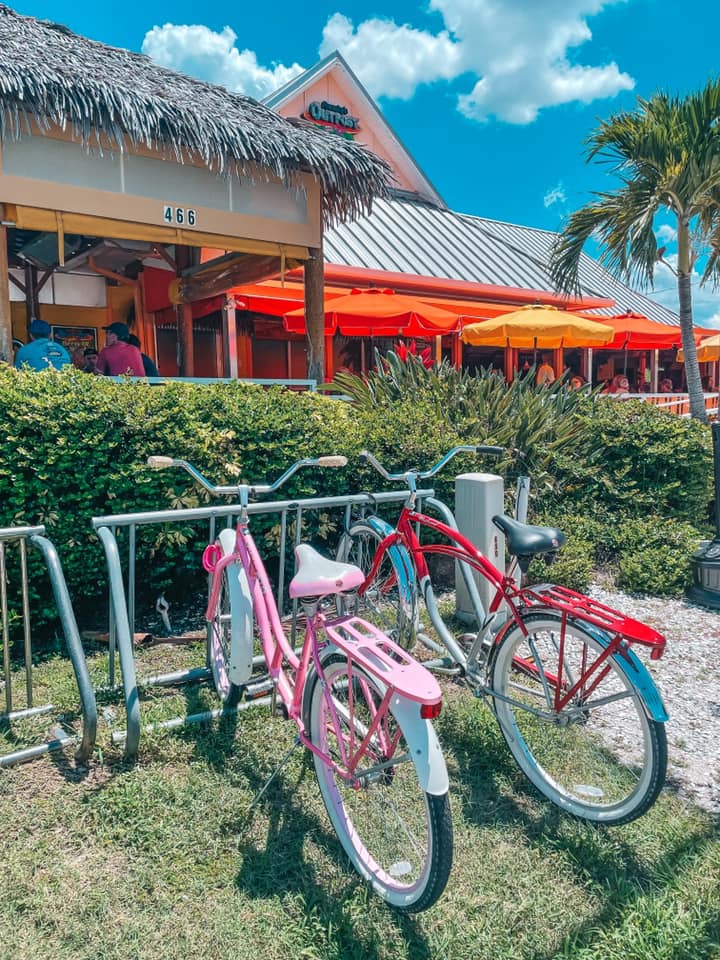 red and pink bikes on bike rack outside of Frenchy's Outpost in Dunedin