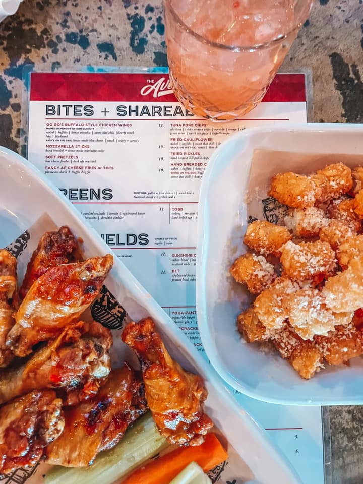wings, tater tots, and a cocktail on top of menu from The Avenue in St. Pete