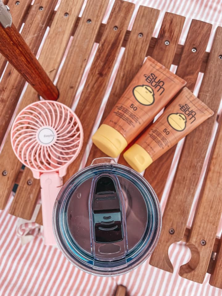 pink fan, sunscreen, and mug on wooden table. fun date ideas in tampa