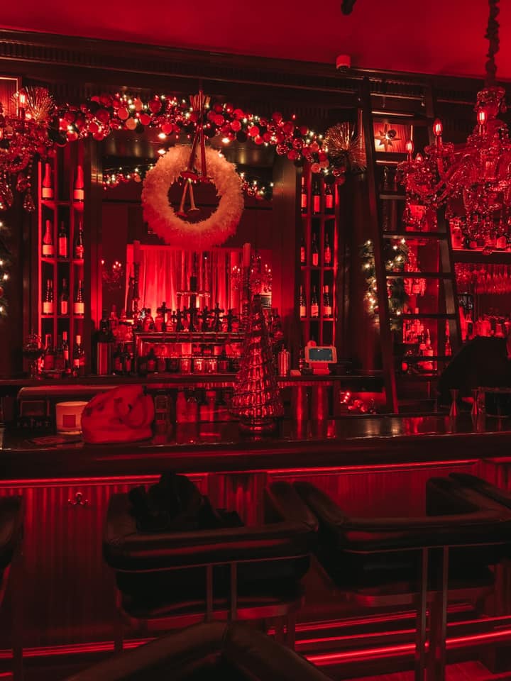 The Saint Speakeasy in St. Pete bar area with red lighting 