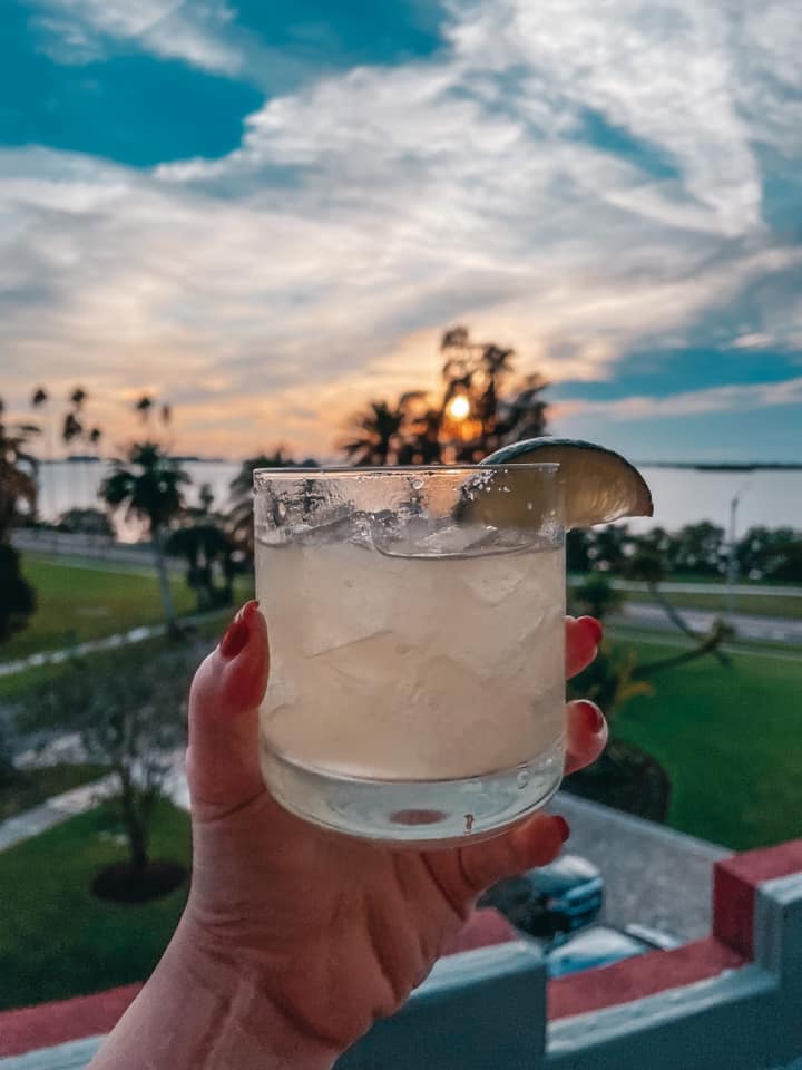 Margarita from Hifi rooftop in Dunedin being held up at sunset with the views in the background