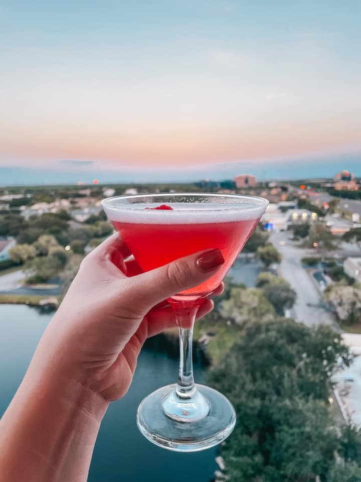 Karol rooftop martini held up with sunset views