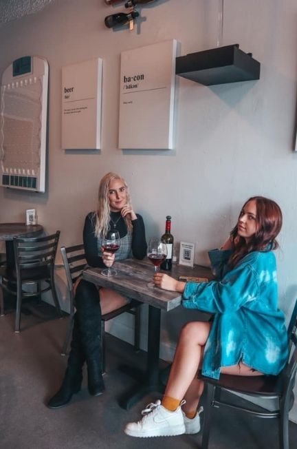 Two women enjoying glasses of red wine at a wine bar in downtown St. Pete