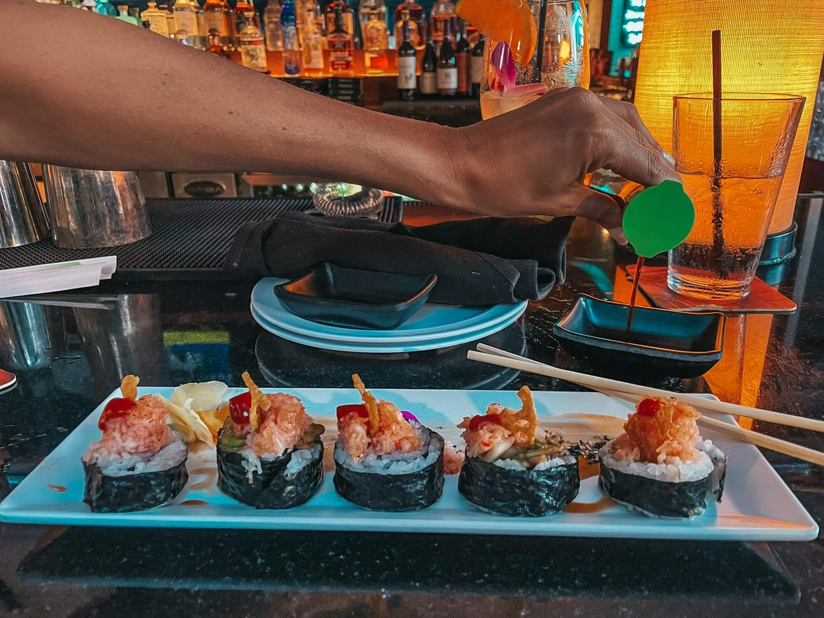 Woman pouring soy sauce for sushi from Haiku in Tampa