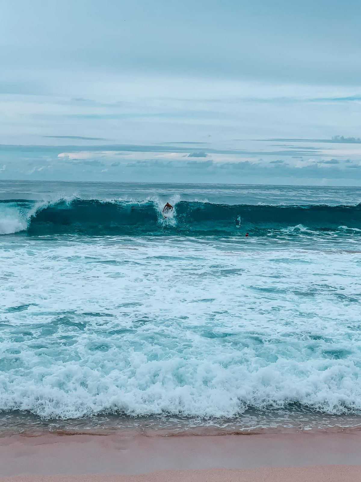 surfers surfing the Banzai Pipeline on Oahu's North Shore