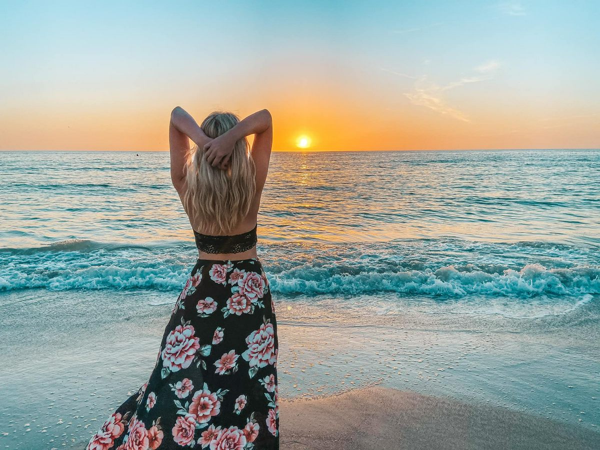 Woman embracing sunset on St. Pete Beach, Florida