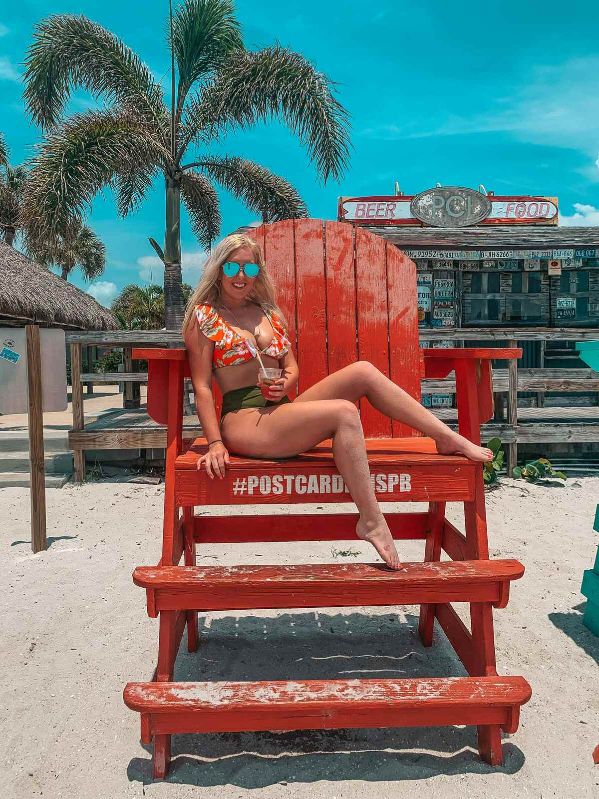 woman sitting on giant chair at post card inn on st pete beach