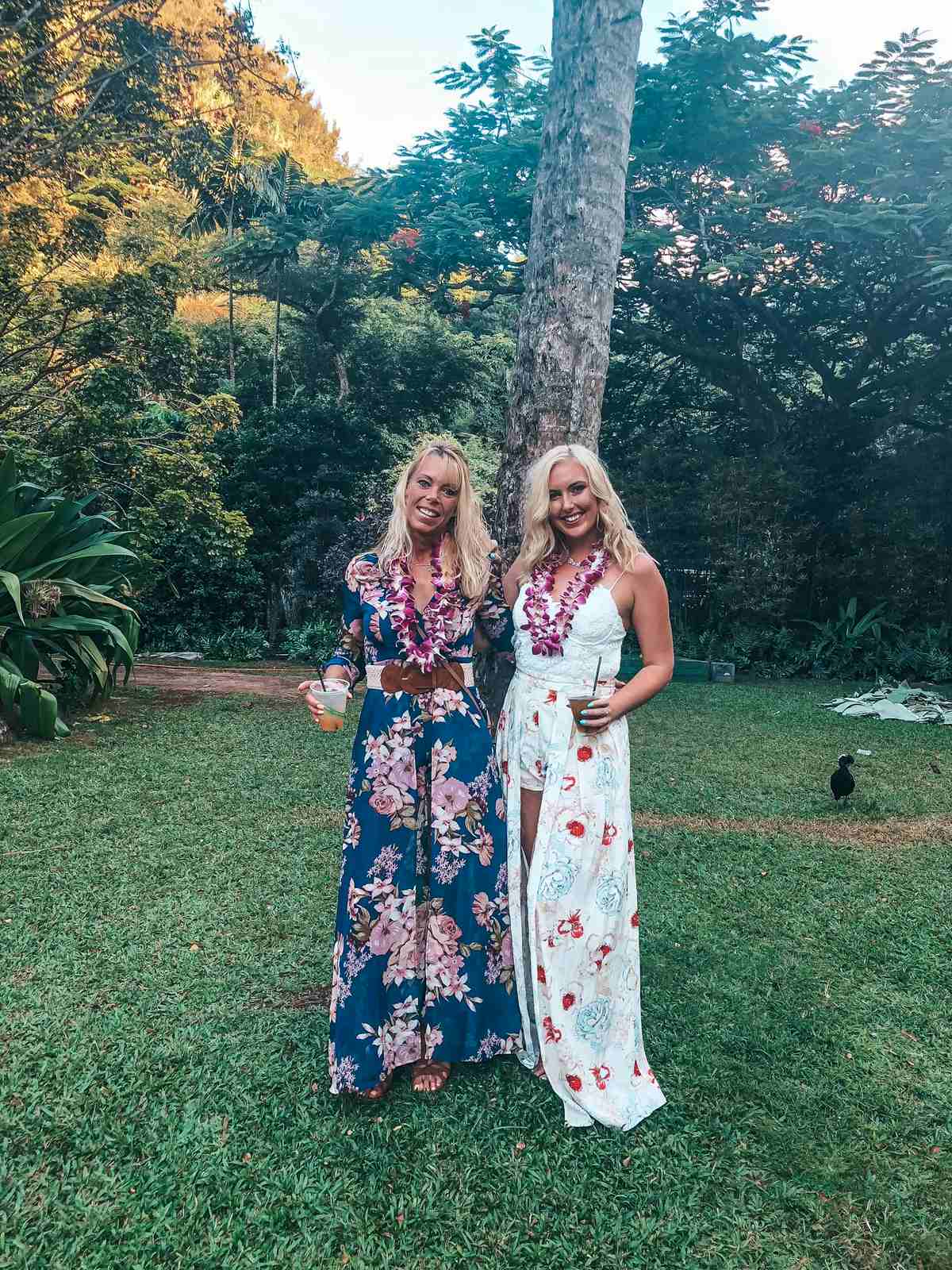 Two women in dresses with leis at a luau on North Shore