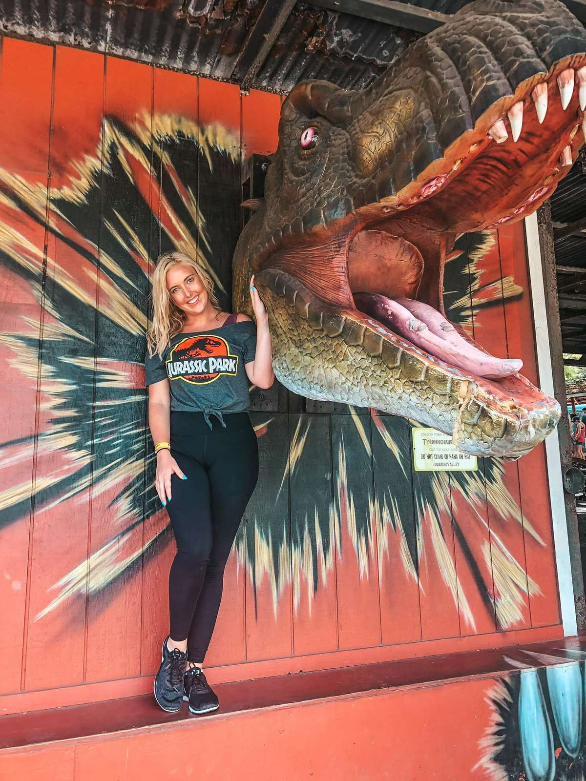 Woman in jurassic park shirt by giant t rex head at Kualoa ranch near Kailua and Kaneohe Oahu