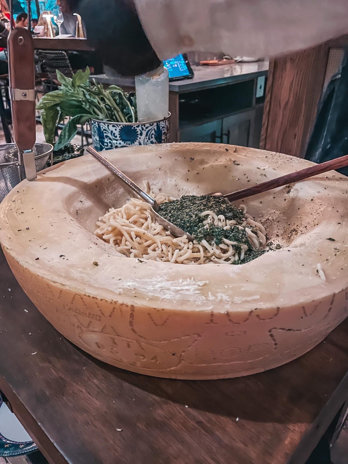 Timpano tableside pasta prep in giant parmesan cheese wheel