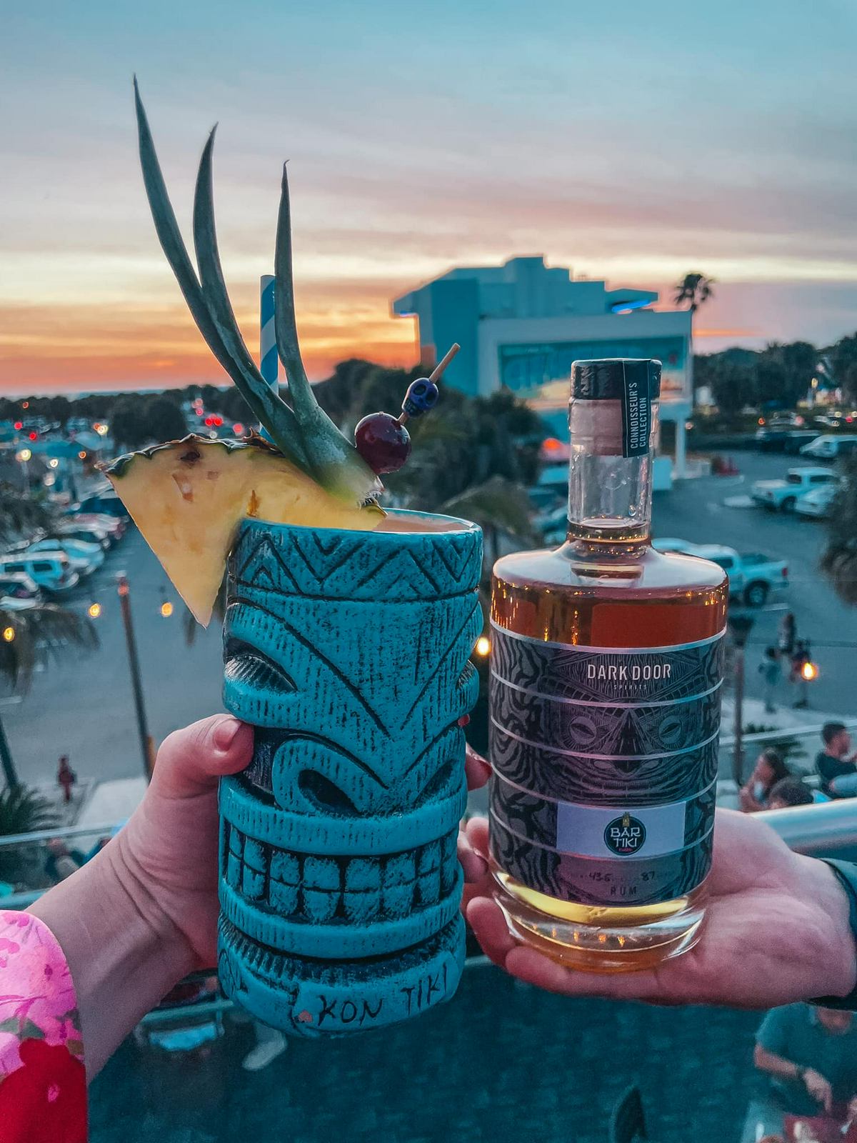Dark Door Spirits rum and tiki drink from Bar Tiki with sunset on Clearwater Beach in the background