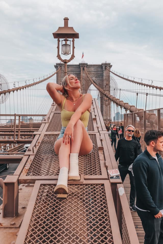 Woman sitting on the Brooklyn Bridge in New York City