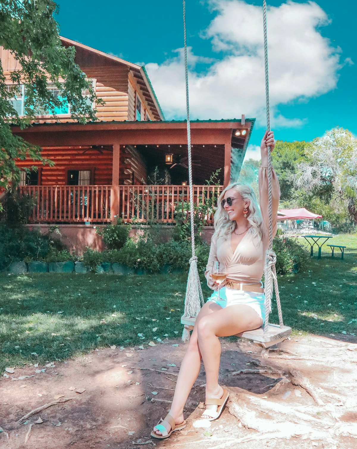 Woman enjoying white wine on the swing at DA Winery