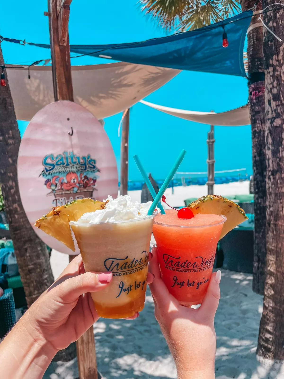 two people showing Frozen drinks from Salty's Beach Bar in St Pete Beach for a florida bachelorette