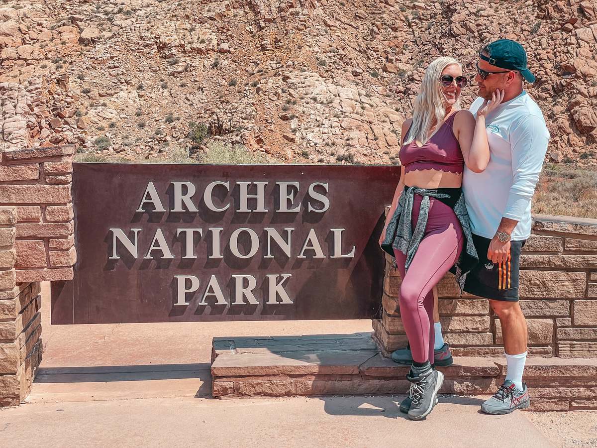 Couple at Arches National Park entrance, one of Utah's might five