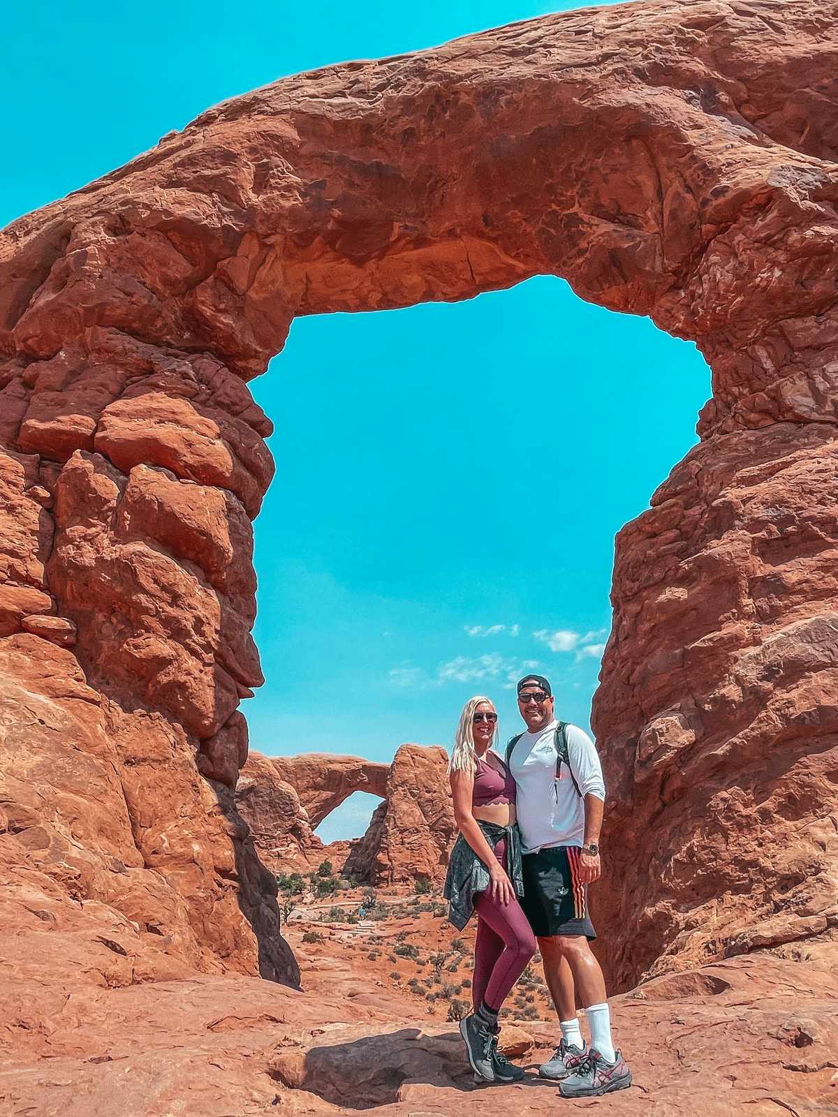 Couple posing at The Windows Section of Arches National Park