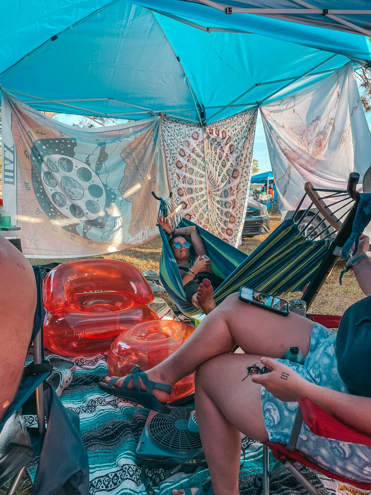 Destiny Snyder laying down on a hammock and sharing camping festival packing list