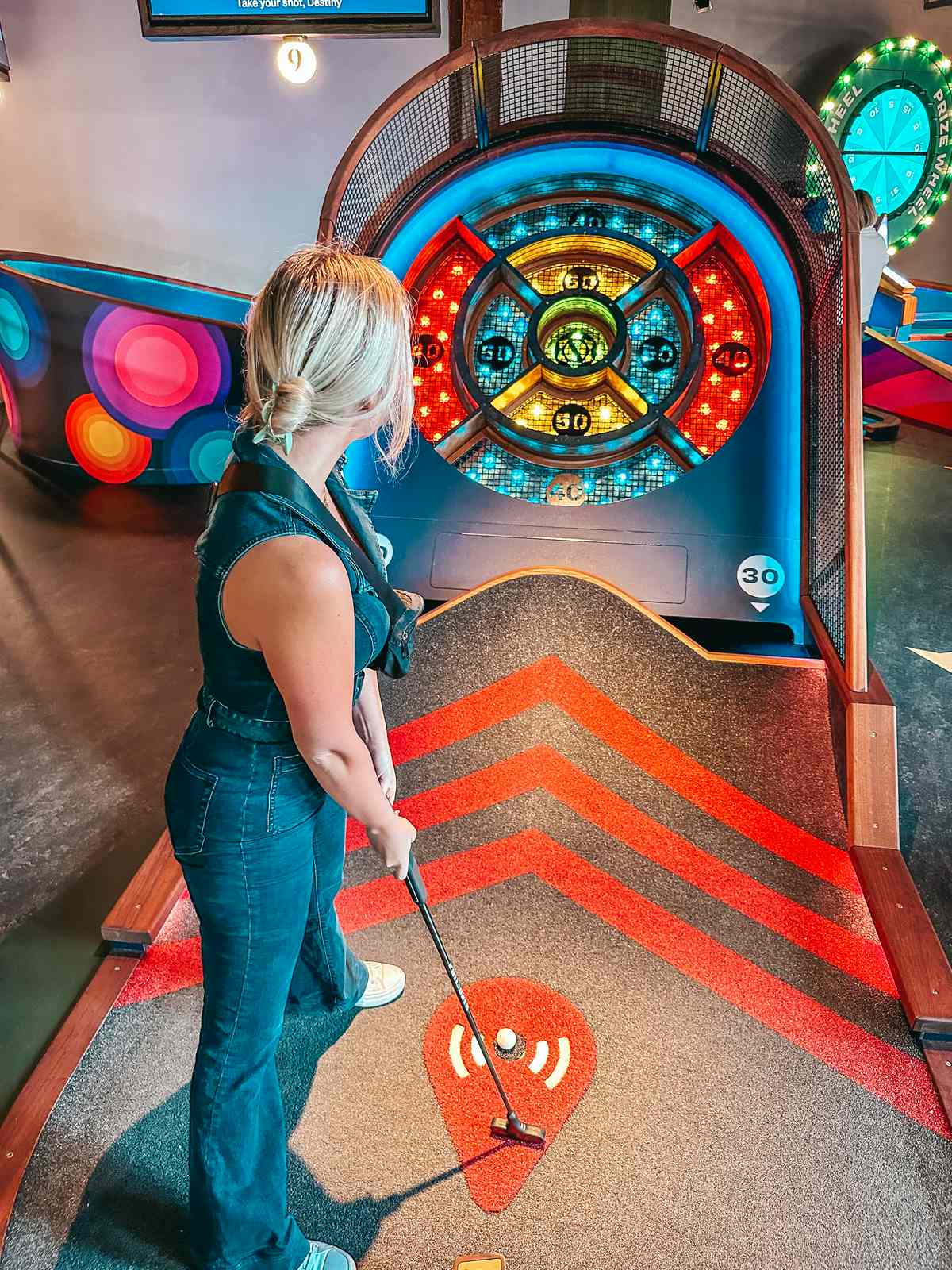 woman enjoying mini golf in City Foundry STL while spending the Weekend in St. Louis 