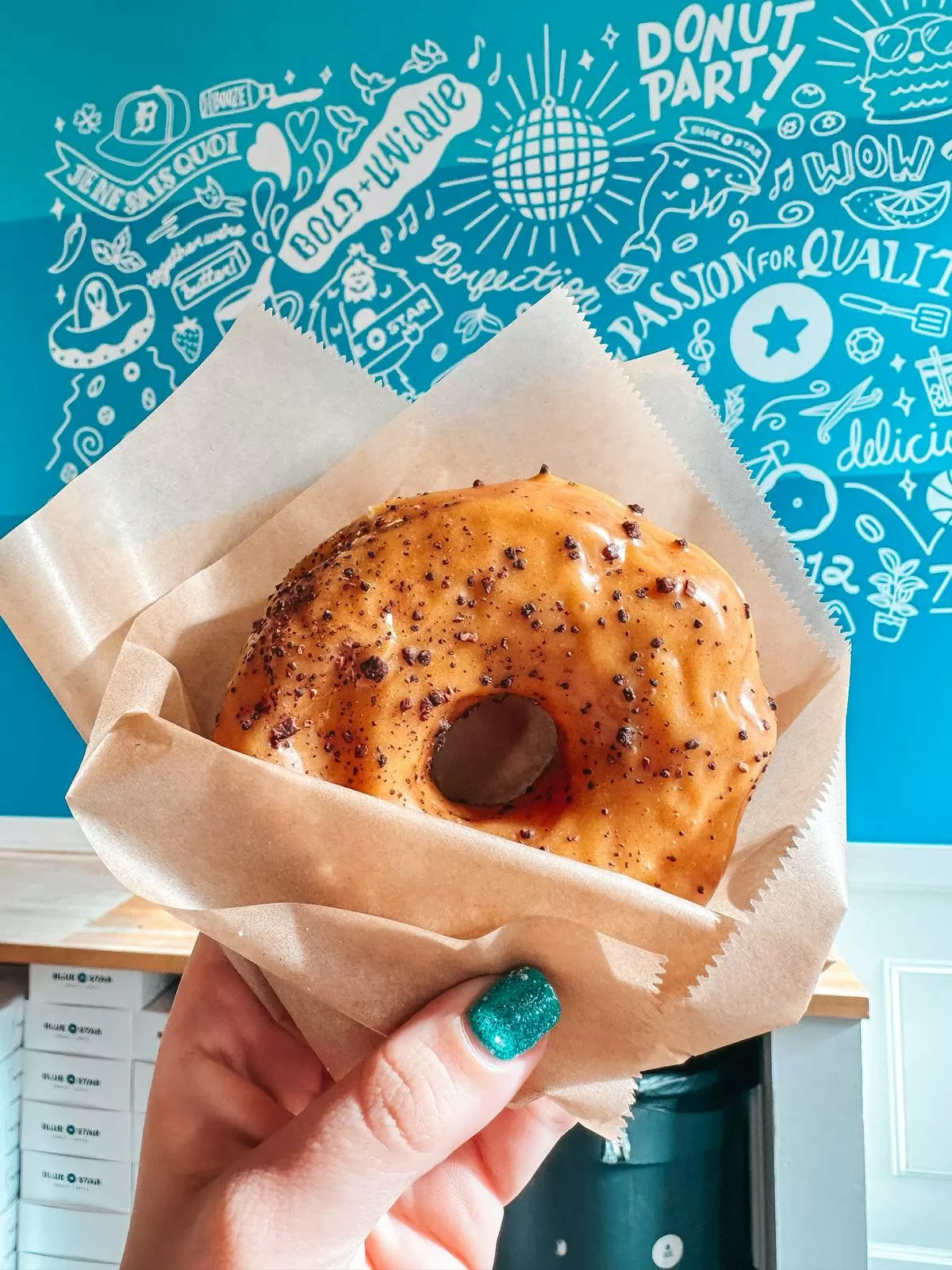 person holding a donut from Voodoo Doughnut