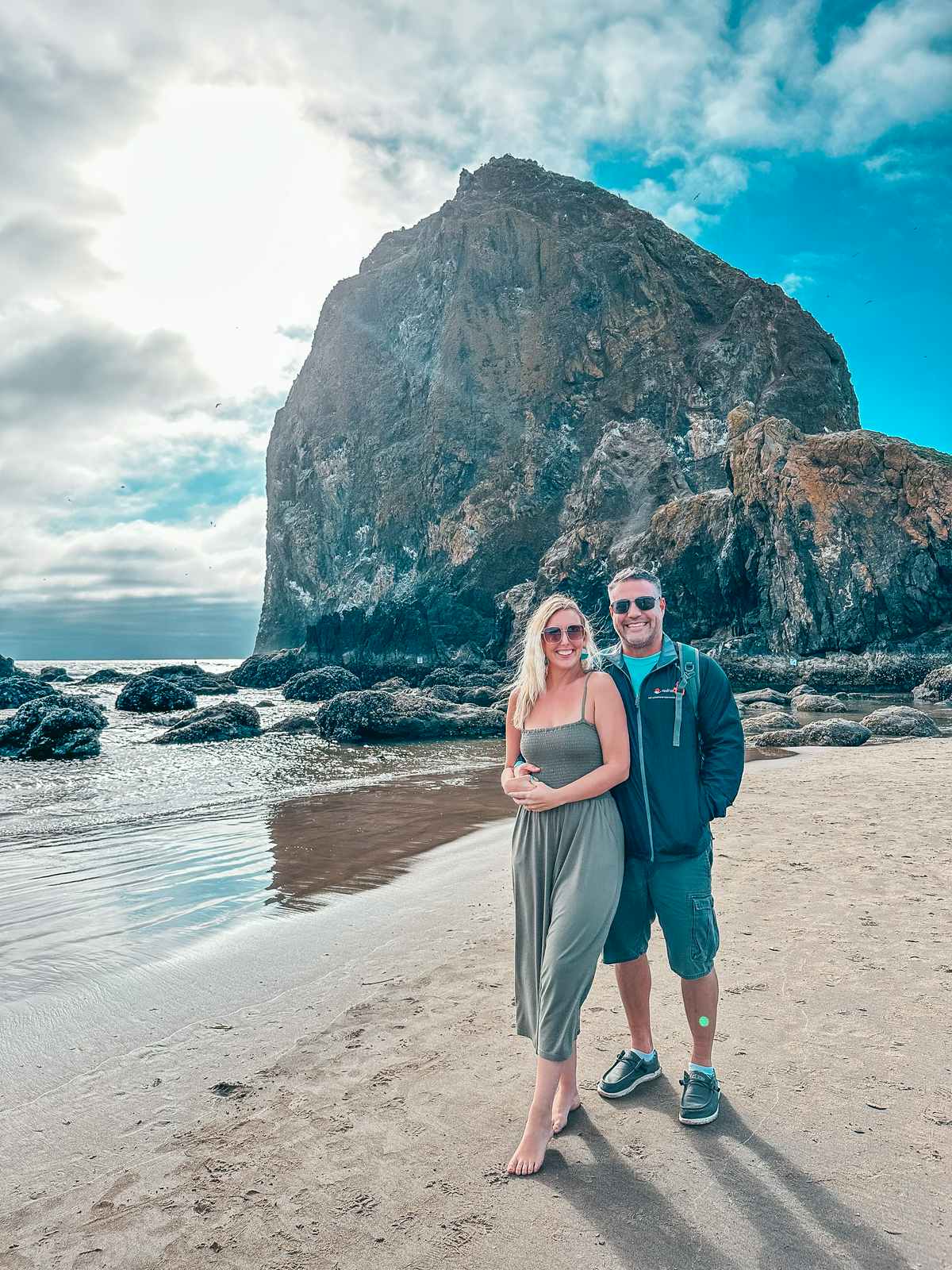 Couple in front of Haystack Rock at Cannon Beach Oregon coast