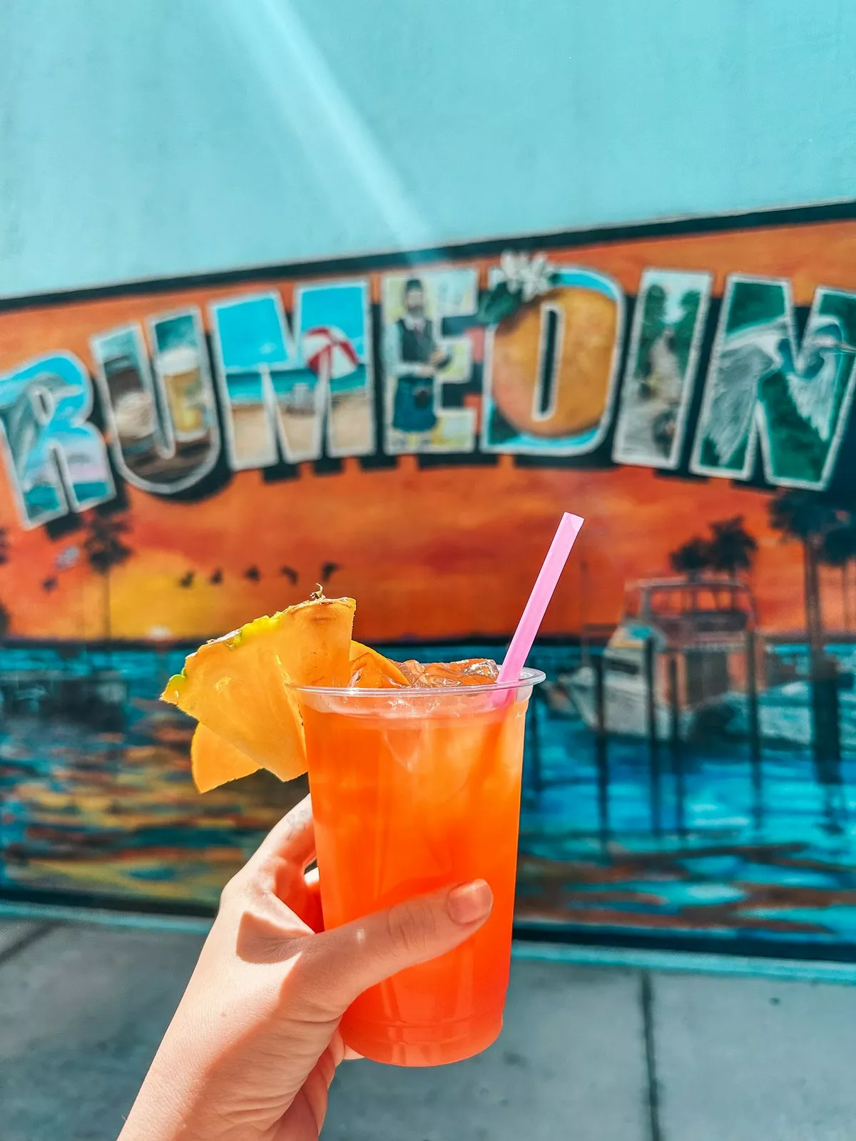 Rum runner in front of Rumedin mural at Cotherman Distilling in Dunedin