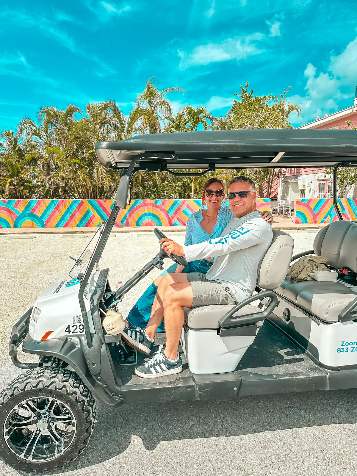 Couple enjoying Zoom Around Golf Cart rental on AMI