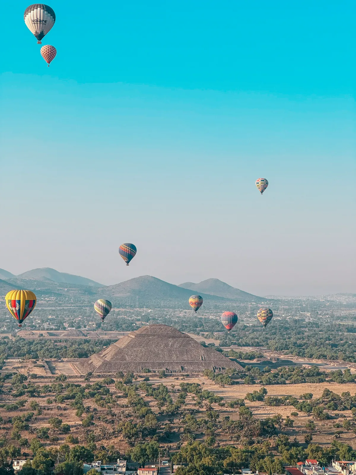 Hot air balloons floating in the sky over Teotihuacan Pyramids at sunrise CDMX