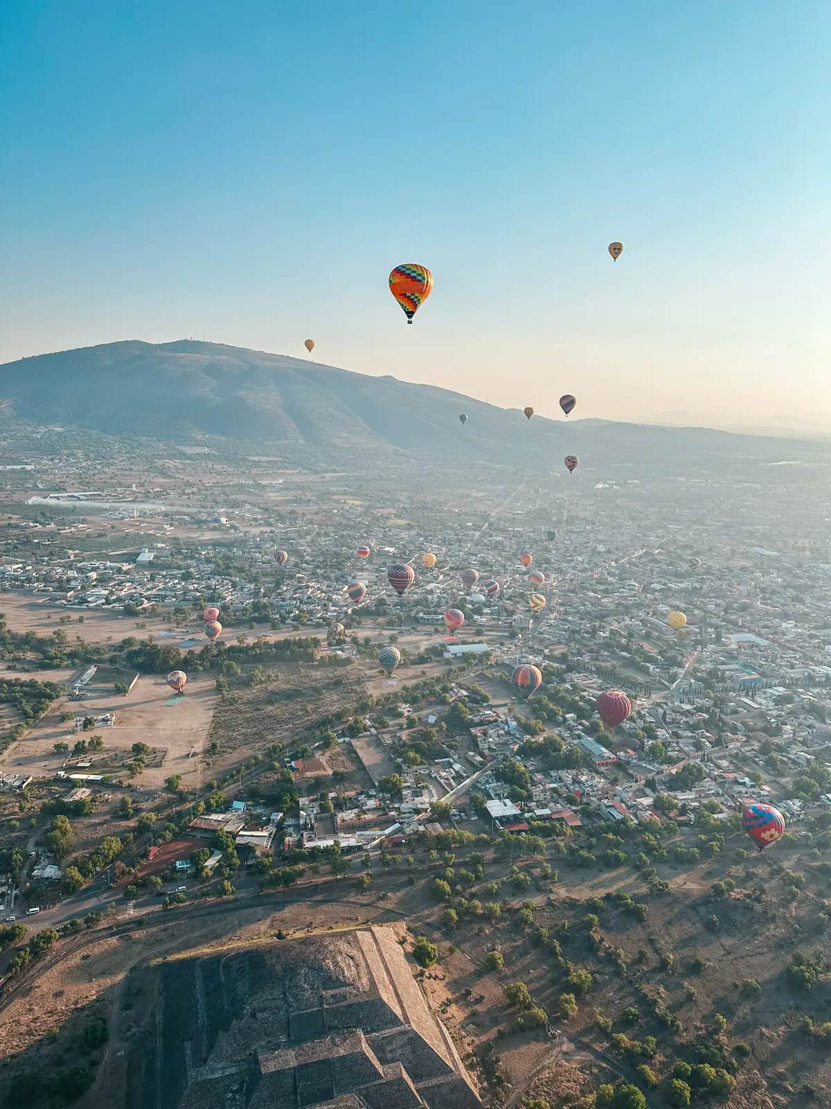 Hot air balloons floating in the sky over Teotihuacan Pyramids at sunrise near Mexico City